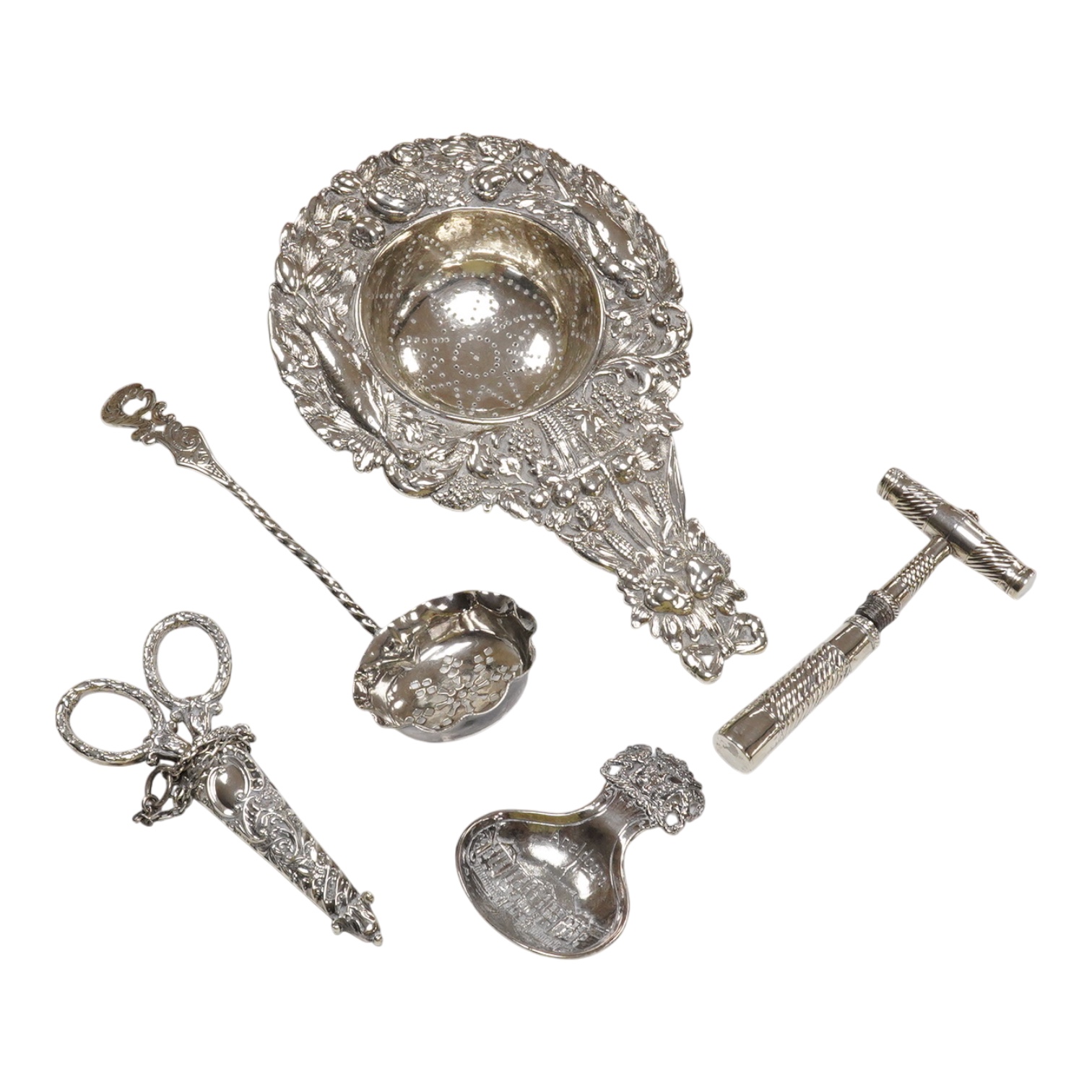 Small silver and white metal, including an Edwardian silver tea strainer, import marks for London, 1908, 15.7cm, a late Victorian silver sifter spoon, silver handled scissors with case, a white metal corkscrew and a whit